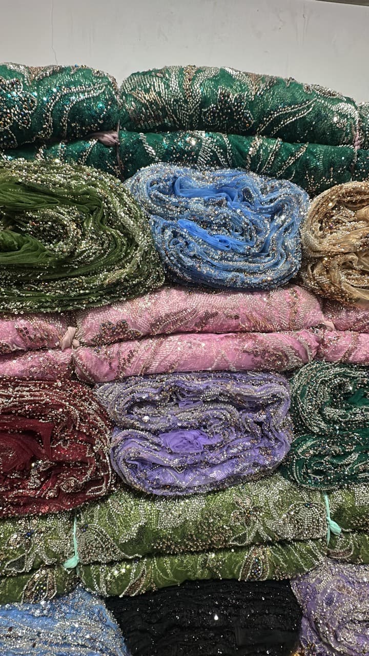 Different types of lace fabrics displayed side by side, showing patterns, textures, and varying fabric weights